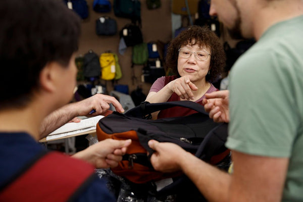 TOM BIHN crew examining and discussing the back of a Synik backpack.